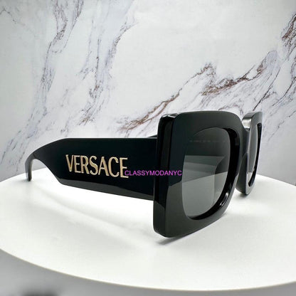 VERSACE VE4496U Gb1/87 black oversized sunglasses gold logo with grey lens side view.