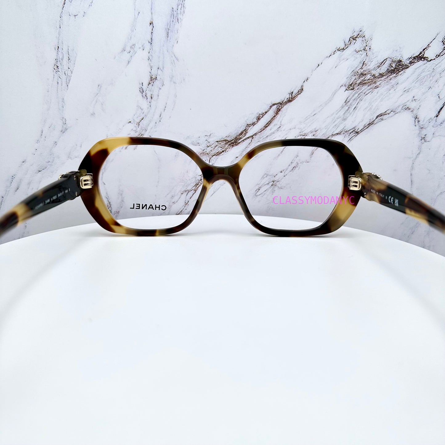 Chanel Tortoiseshell glasses on a white surface with a marble-patterned background