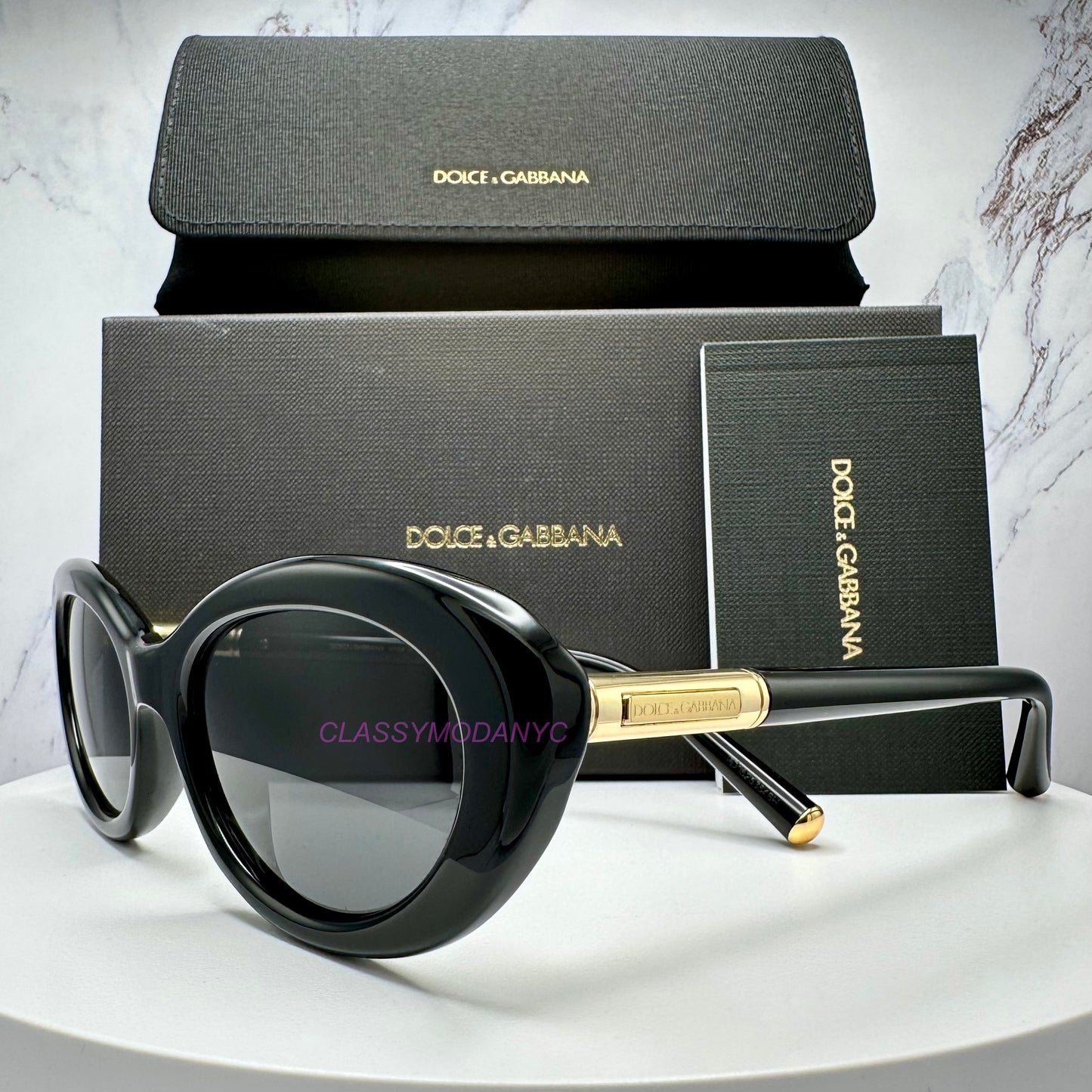 Dolce & Gabbana DG4519 501/87 sunglasses with black frame and gold accents, displayed in front of branded packaging.