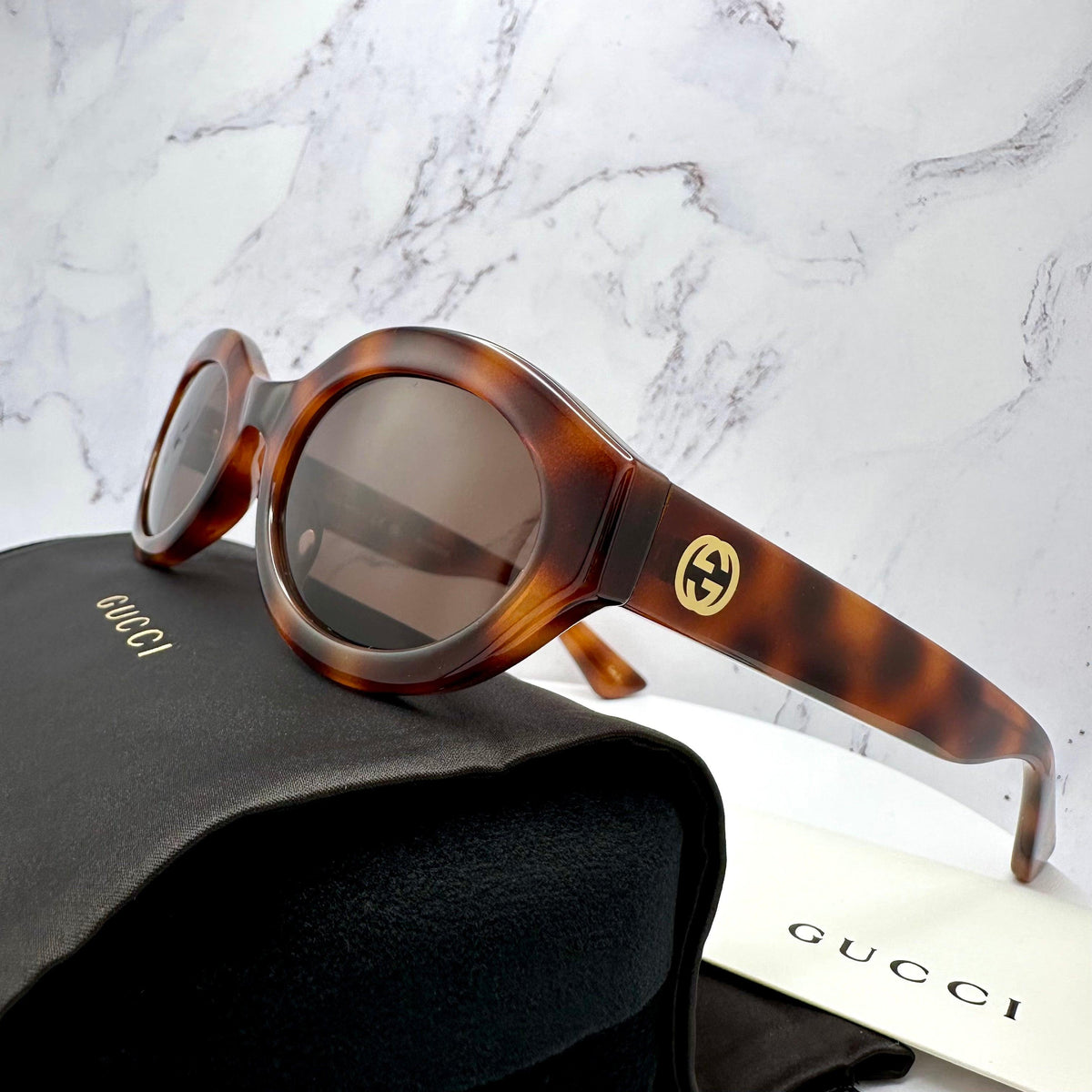 Gucci GG1579S 002 brown oval tortoise shell women's sunglasses with gold GG logo side view