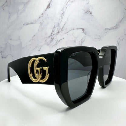 Gucci GG0956S 003 black acetate women's sunglasses with gold metal GG logo angle view