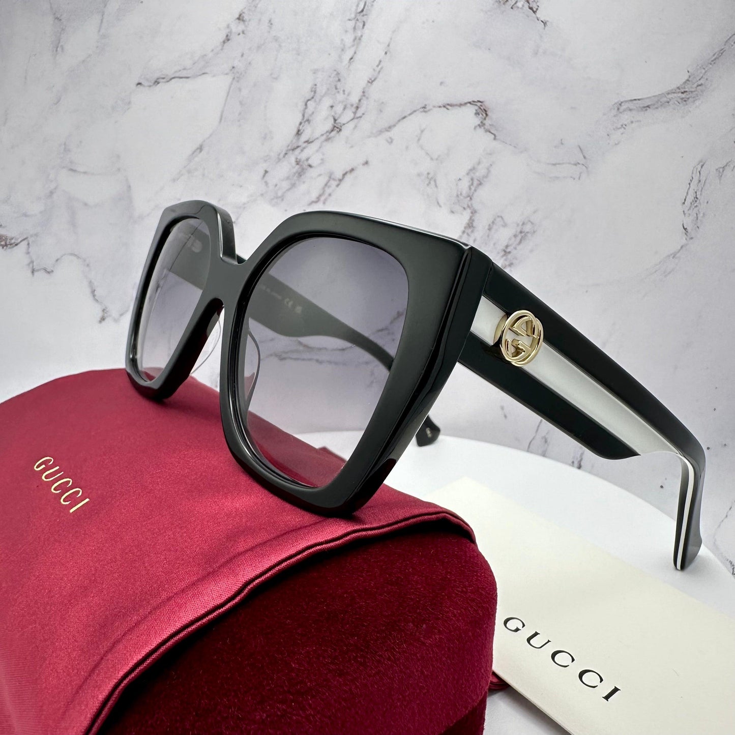 Gucci GG1300S 004 black oversized square sunglasses web arms gold logo.