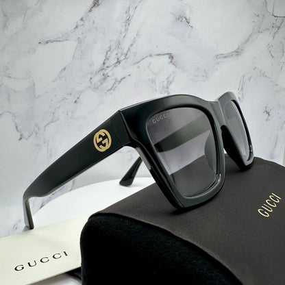 Gucci GG1714S 001 black sunglasses with gold logo on authentic Gucci case.