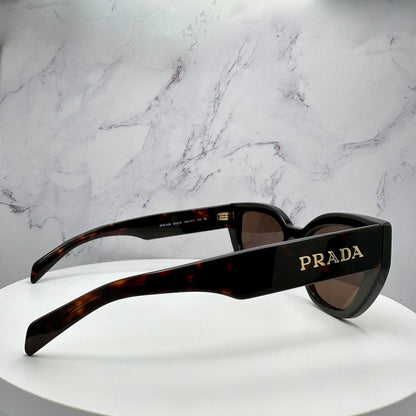 PRADA PRA09S 16N5Y1 brown cat eye sunglasses with gold metal logo on temple arm side view.