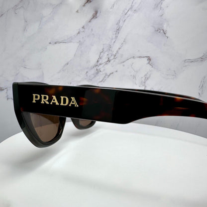 PRADA PRA09S 16N5Y1 brown cat eye women's glasses with gold metal logo on temple arm side view.