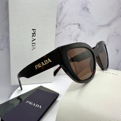 PRADA PRA09S 16N5Y1 brown cat eye sunglasses with gold metal logo side view.