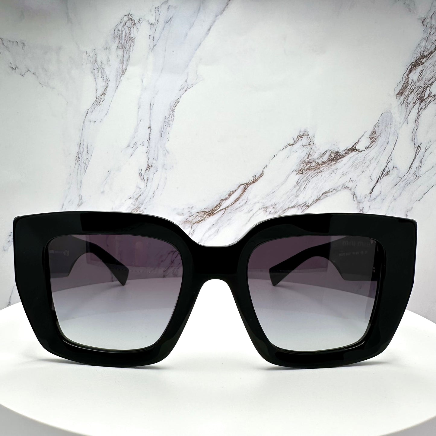 MUB05S 16K90A Miu Miu black sunglasses with gold accents front view 