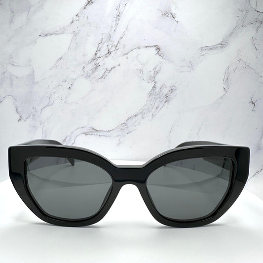 PRADA PRA09S 1AB5S0 black cat eye butterfly women’s sunglasses with gray solid lenses, silver Prada lettering and acetate frame.
