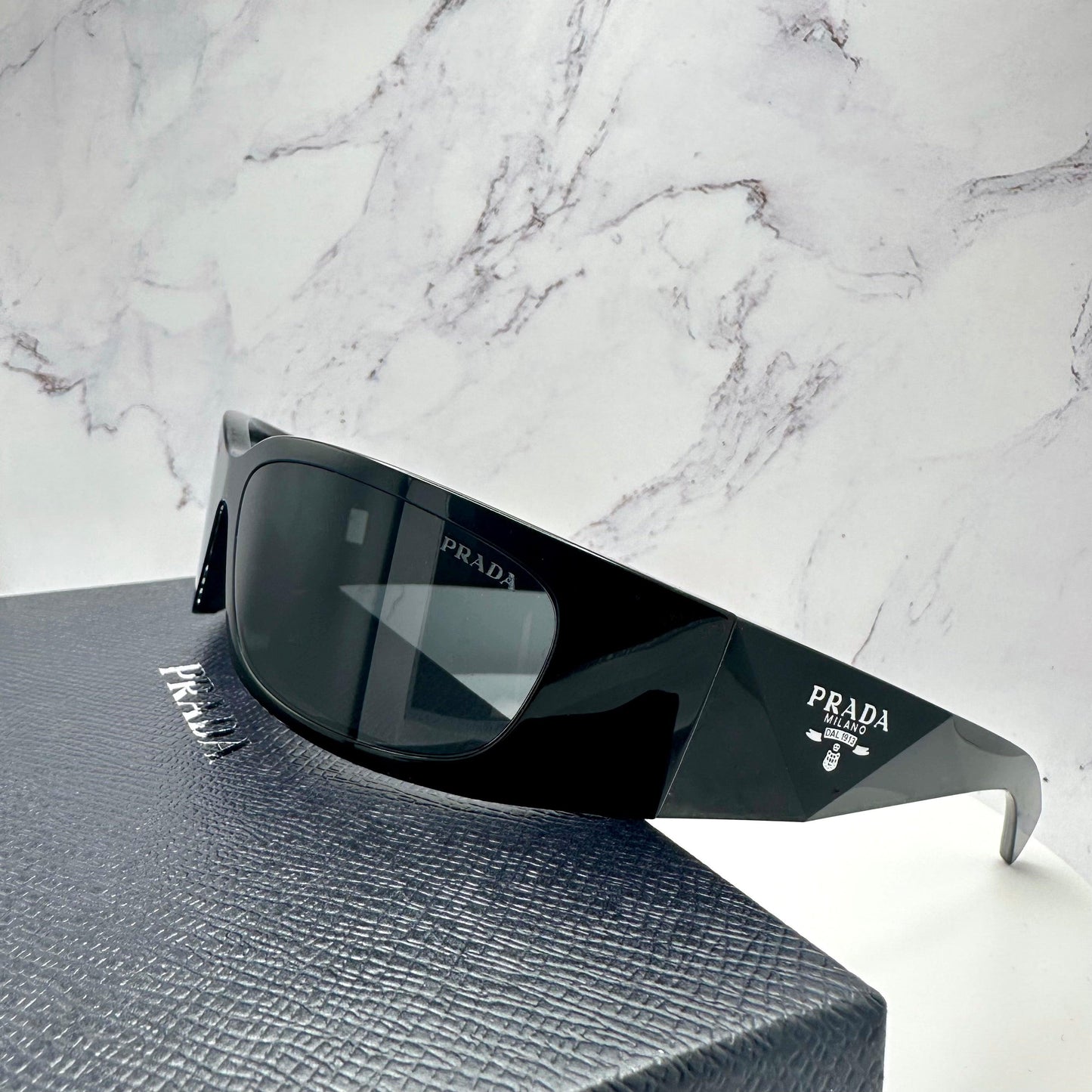 PRADA 0PRA14S 1AB5S0 metallic silver symbole logo sunglasses side view on Prada box