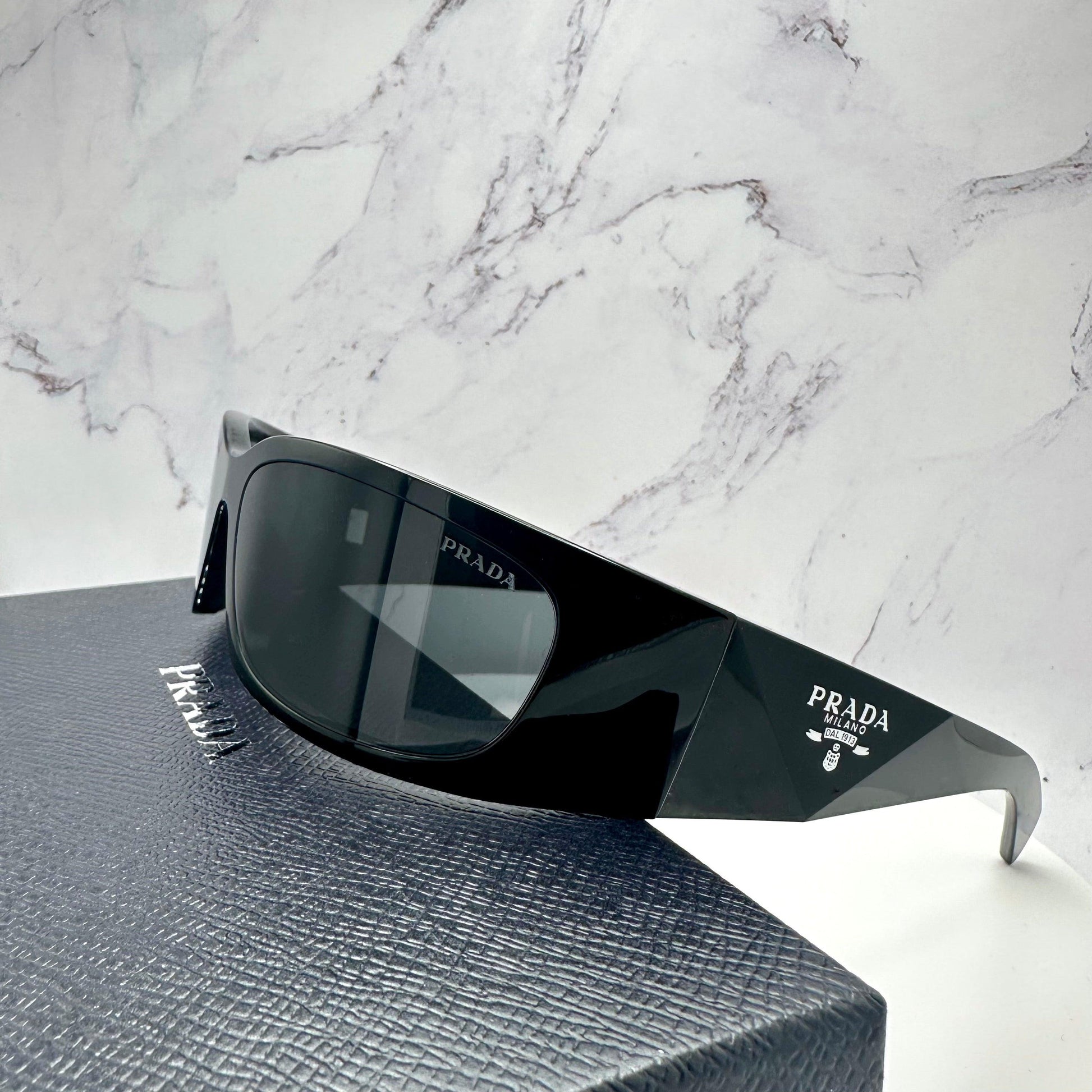 PRADA 0PRA14S 1AB5S0 metallic silver symbole logo sunglasses side view on Prada box